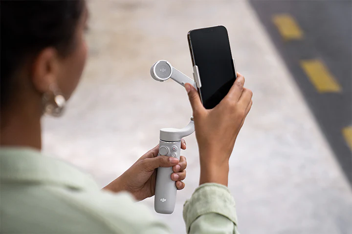 مگنت هولدر موبایل اسمو موبایل DJI OM Magnetic Phone Clamp 3 در حال استفاده روی گوشی در خیابان
